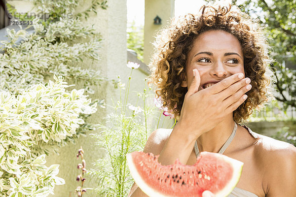 Lächelnde Frau isst Wassermelone