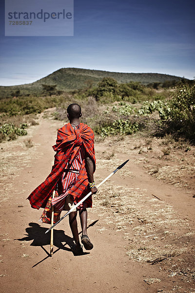 Maasai-Mann auf unbefestigtem Weg