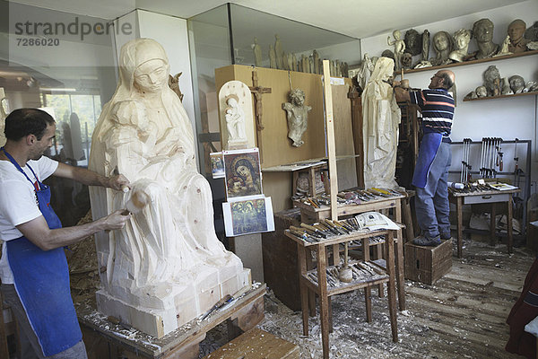 Bildhauer meißeln Figuren aus Holz