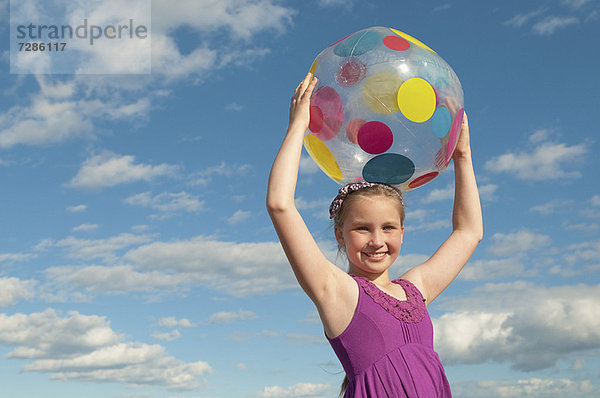 Lächelndes Mädchen mit Strandball im Freien