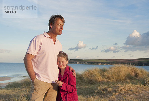 Vater und Tochter umarmen sich am Strand