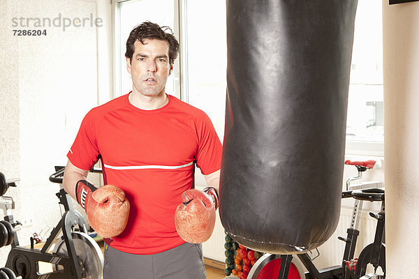 Mann mit Boxsack im Fitnessstudio