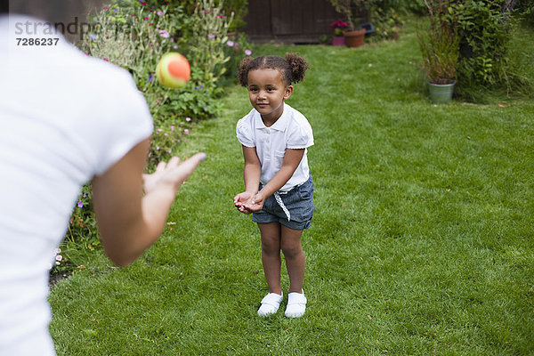 Mutter und Tochter spielen im Garten