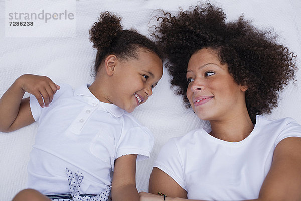 Mutter und Tochter auf dem Bett liegend