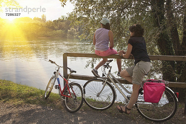 Frauen mit Fahrrädern entspannt am Fluss