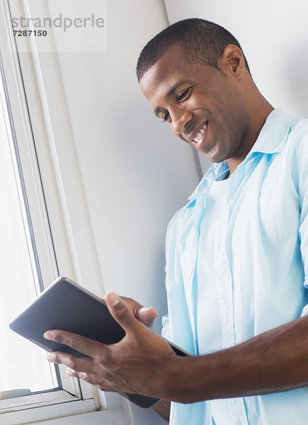Junger Mann mit digitalen tablet