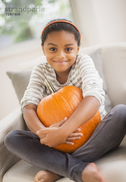 sitzend  Portrait  Couch  lächeln  Kürbis  5-9 Jahre  5 bis 9 Jahre  Mädchen