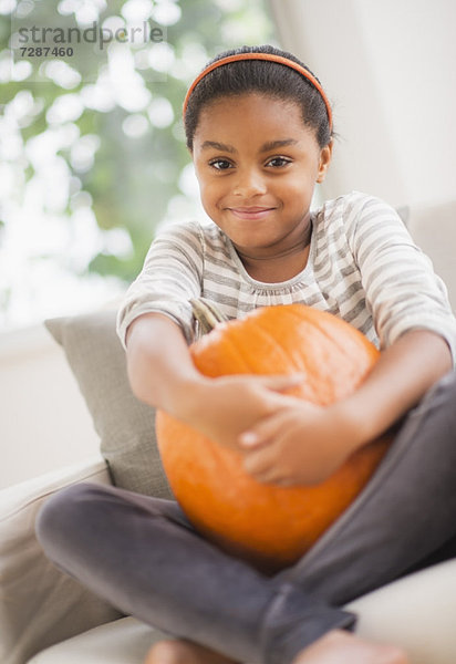 sitzend  Portrait  Couch  lächeln  Kürbis  5-9 Jahre  5 bis 9 Jahre  Mädchen