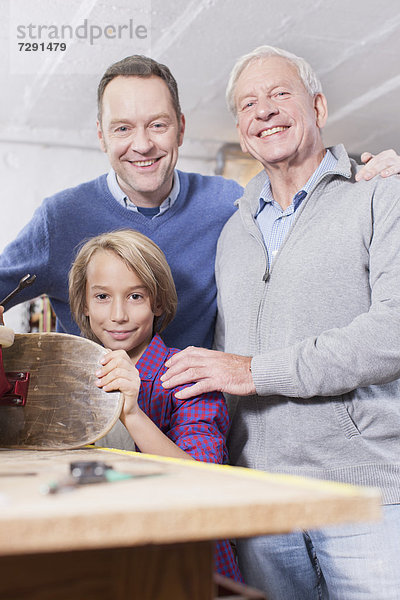 Germany  Leipzig  Grandfather  father and son repairing skateboard