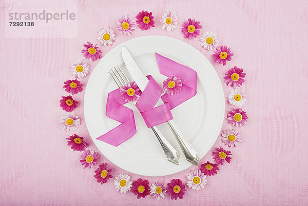 Place setting with daisy flower on tablecloth