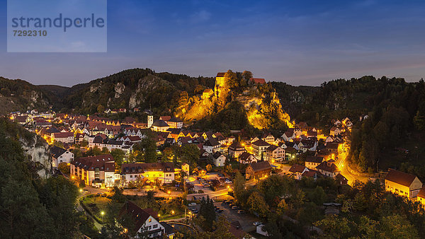 Deutschland  Bayern  Blick auf die Burg Pottenstein auf dem Berg mit der Stadt im Vordergrund bei Nacht