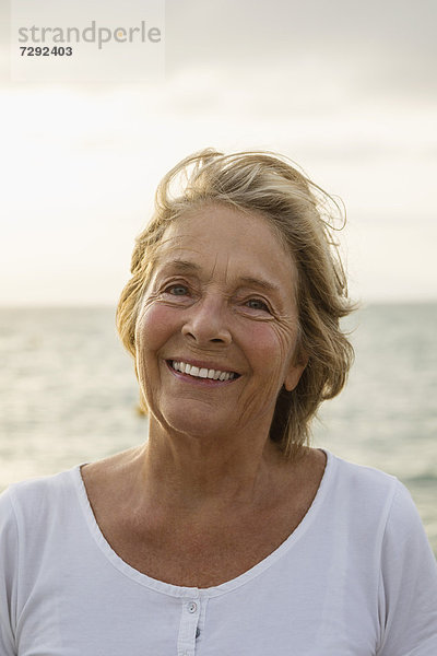 Spain  Senior woman at the sea  smiling