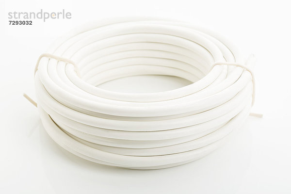 Close up of rolled electric cable on white background