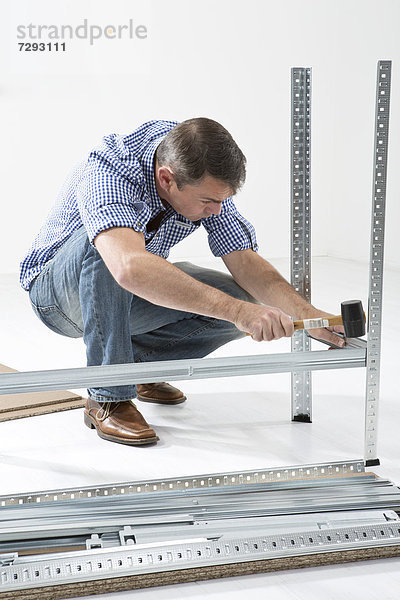 Mature man building shelf