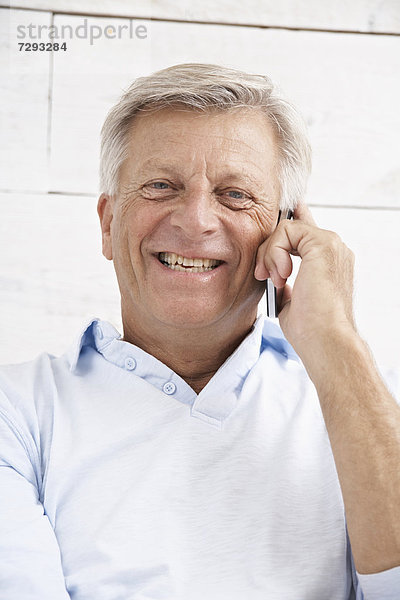Spain  Senior man talking on mobile  smiling  portrait