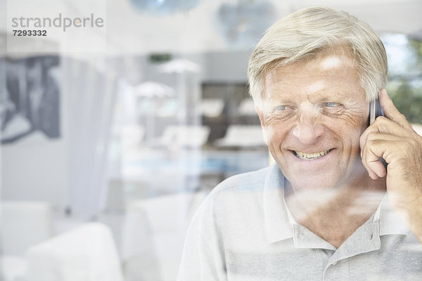 Spain  Senior man talking on mobile  smiling