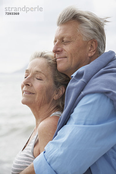 Spain  Senior couple on beach at Atlantic  smiling