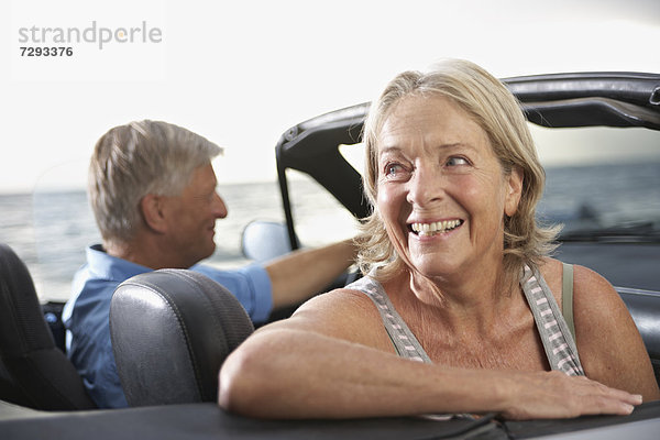 Spain  Senior couple in convertible car  smiling