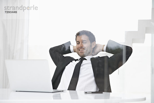 Spanien  Geschäftsmann schaut auf Laptop  lächelnd