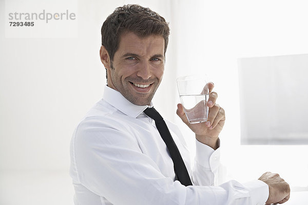 Spain  Businessman holding water glass  smiling  portrait