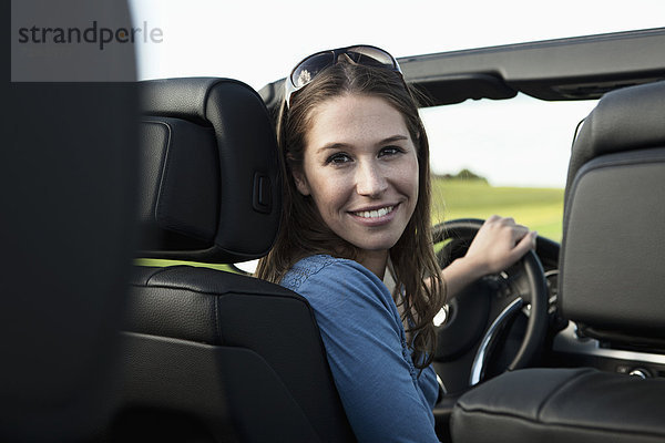 Junge Frau im Auto  lächelnd