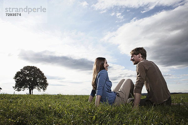 Germany  Bavaria  Couple sitting in field