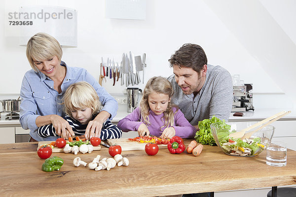 Germany  Bavaria  Munich  Family preparing food in kitchen