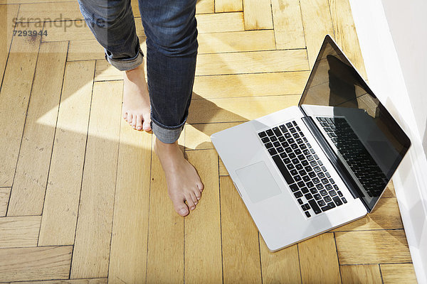 Junge Frau Füße zu Fuß mit Laptop