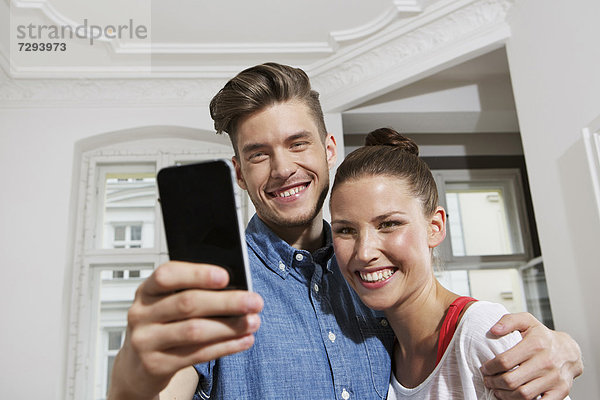 Young man and woman using smart phone  smiling