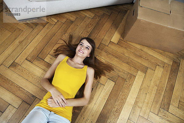 Young woman lying on floor  smiling