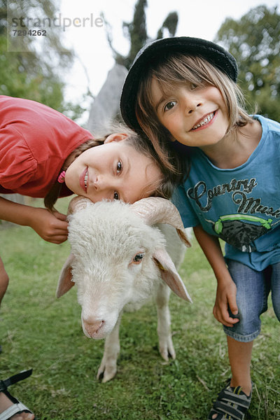 Junge und Mädchen mit Schafen im Kinderlager