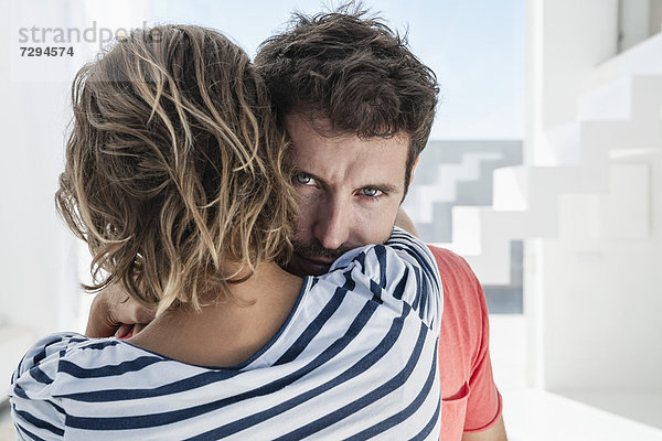 Spanien  Mittleres erwachsenes Paar  das sich in einem modernen Appartement umarmt.