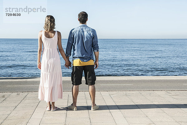 Spanien  Mittleres erwachsenes Paar am Atlantik stehend  mit Blick auf den Atlantik