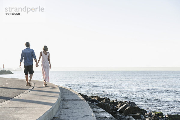 Spain  Mid adult couple walking along coast