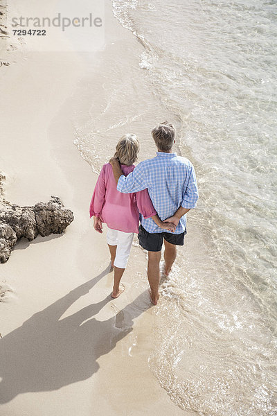 Spain  Seniors couple walking along beach