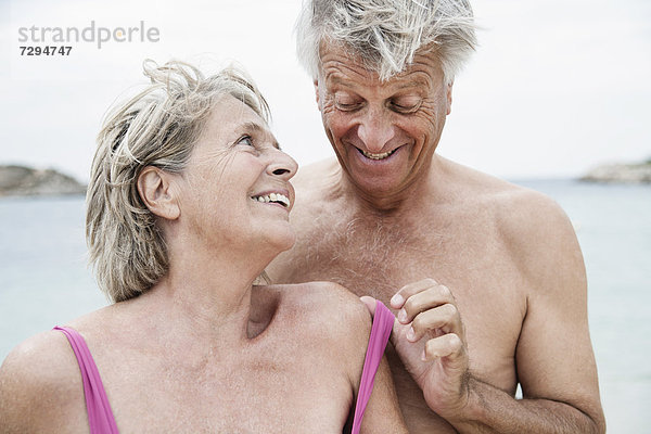 Spain  Senior couple undressing on beach