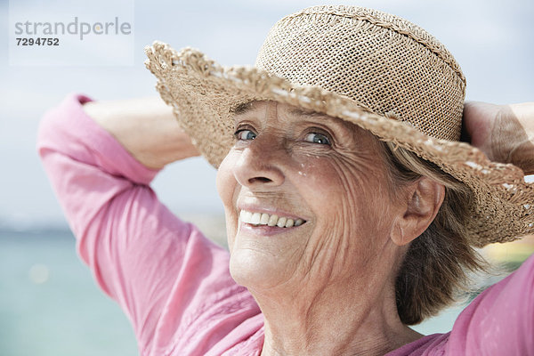 Spain  Senior woman with straw hat  smiling