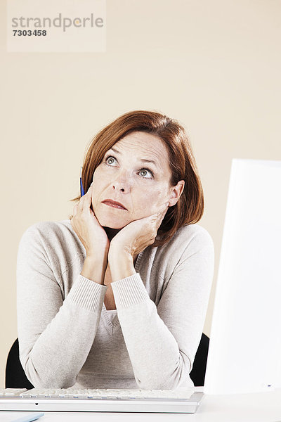 Frau sitzt nachdenklich am Computer