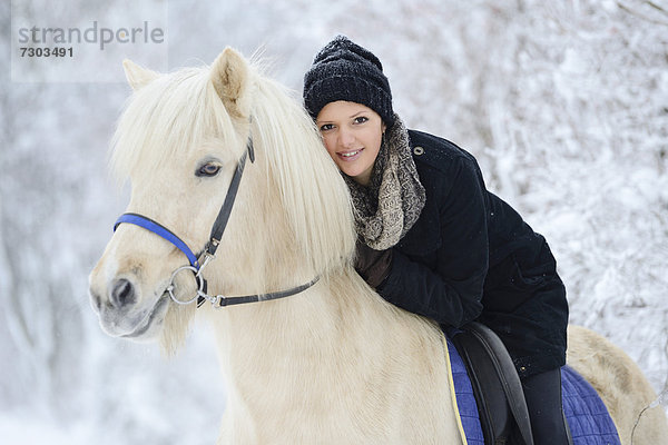 Junge Frau auf Pferd im Schnee