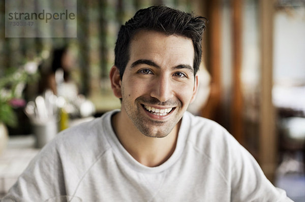 Portrait eines glücklichen jungen Mannes im Restaurant