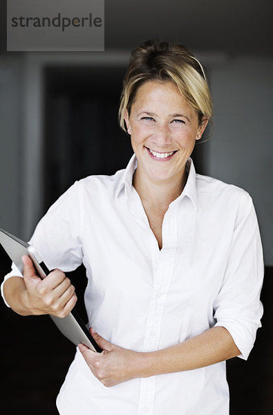 Porträt einer glücklichen Geschäftsfrau mit Laptop im Büro