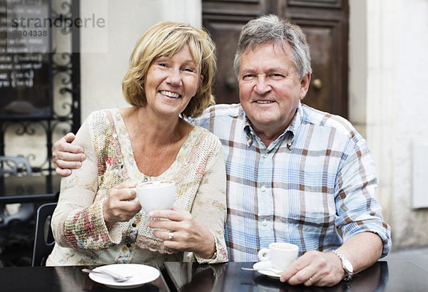Porträt eines glücklichen Paares beim Kaffee am Tisch