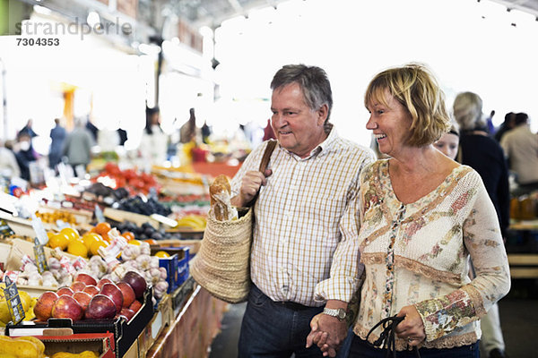 Glückliches Paar schaut sich die Früchte auf dem Markt an