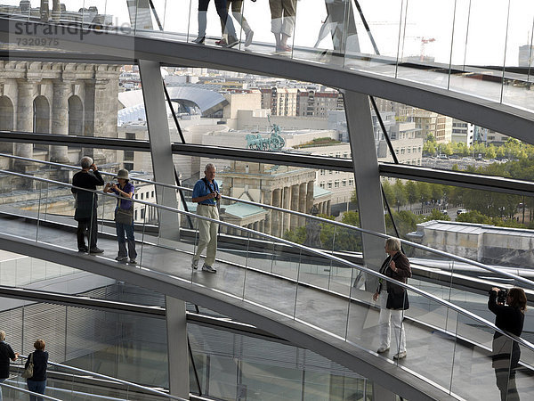 Touristen und Besucher im Innern der Reichstagkuppel mit Blick auf das Brandenburger Tor  Berlin  Deutschland  Europa