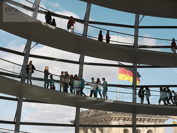 Besucher und deutsche Nationalflagge in der Reichstagskuppel  Berlin  Deutschland  Europa