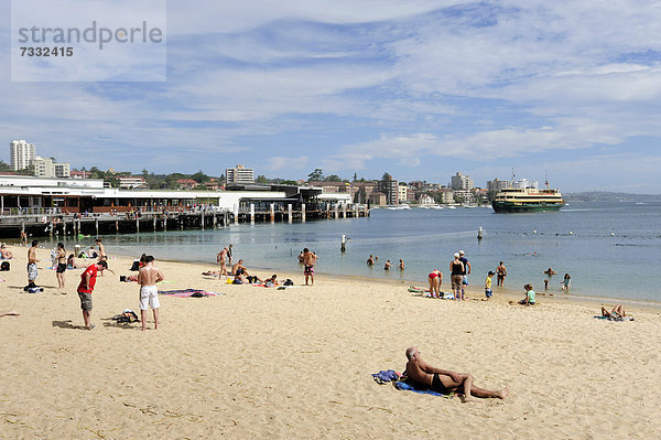 Kleiner Strand bei Manly Wharf  dahinter eine Fähre in der Bucht von Manly Cove  North Sydney  New South Wales  NSW  Australien