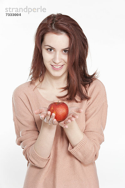 Lächelnde junge Frau mit einem Apfel