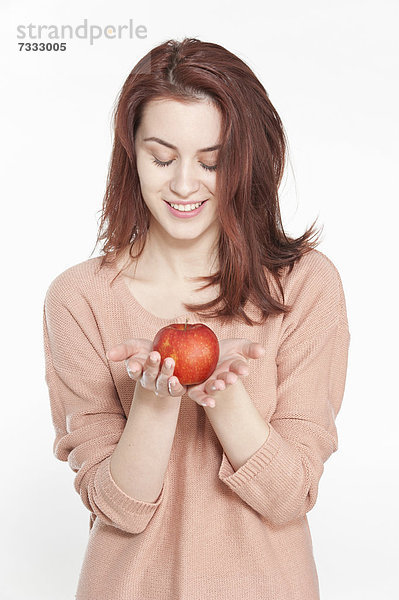 Lächelnde junge Frau mit einem Apfel