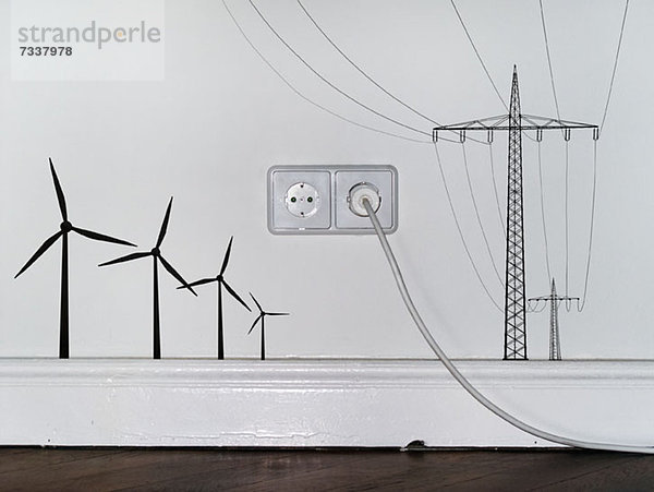 Steckdose zwischen Abziehbildern von Windkraftanlagen und Strommasten
