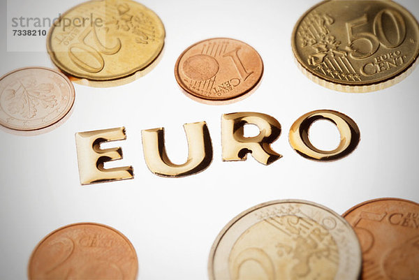 Einzelwort Geld in goldener Schrift  umgeben von Euro-Münzen